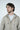 A man with wavy brown hair and a beard wears a Deerfield Hoodie Dark Khaki, made from super soft cotton with a fleece interior, over a white t-shirt while gazing to his left against a plain white background.