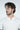 A man with wavy brown hair and a beard wearing the Big League Notched V-Neck Short Sleeve White tee exudes a relaxed vibe while looking to the side against a plain background, embodying the essence of a laid-back hangout.