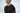 A man stands against a plain background wearing the Big League Notched V-Neck Short Sleeve Black shirt, highlighting its notched v-neck design and impeccable fit.