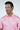 A person with short, dark hair is wearing a Dolphin Tail Pink West Palm Polo, crafted from luxury performance fabric, smiling and looking slightly to the side against a plain, light-colored background.