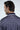 A dark-haired man is seen from behind in a Sarasota Polo: Golf Girl Navy jacket made from luxury performance fabric. The design features repeated people silhouettes with white trim by the collar, displaying VANSON MAXIMUS.