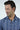 A man with dark hair, wearing a Panhandle Polo: Tropical Oasis in blue patterns, looks down smiling slightly against a white background, staying comfortable and stylish thanks to its wrinkle-resistant and breathable Micro-Pique fabric.
