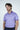 A bearded man with brown hair is wearing a Jaxson Maximus Sarasota Polo in Golf Cart Palm Purple, crafted from luxury performance fabric. Its white pattern adds style, while the four-way stretch offers comfort. He stands against a plain white background, arms relaxed by his sides.