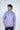 The man wears a purple Key West 1/4 Zip: Golf Cart Palm shirt with a subtle geometric design, gazing to the side with dark hair and light facial hair against a plain, light background. This versatile piece is available in multiple sizes.
