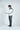 A man stands against a plain background, adjusting his left cuff beneath the sleek elegance of his Jaxson Maximus Brickell Bay Mid Weight 1/4 Zip Pullover in White with Camo.