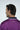 A man with dark hair faces away wearing the Sarasota Polo: Shark Attack Purple shirt featuring luxury performance fabric, a dark collar, white trim, and JAXSON MAXIMUS elegantly emblazoned on the back.
