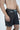 A shirtless individual wears gray Beach To Trail shorts with blue drawstrings, quick dry fabric, and a small zipped pocket on the left. The textured shorts are ideal for activities from beach to trail against a light background.
